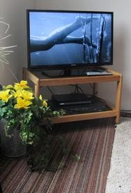 Studio living room with TV stand and yellow flowers at Sea Escape